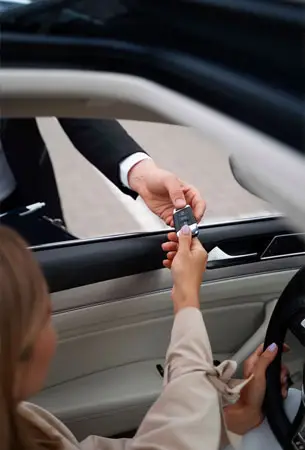 a person handing a car key to another person