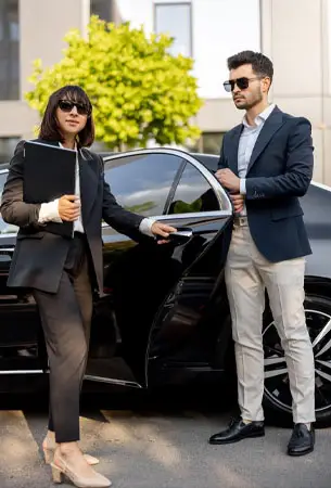a man and woman standing next to a car