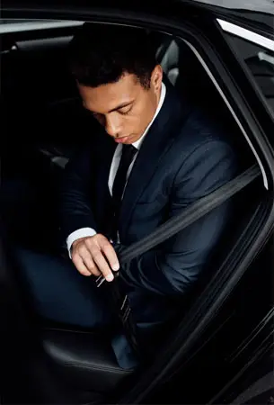 a man in a suit sitting in a car